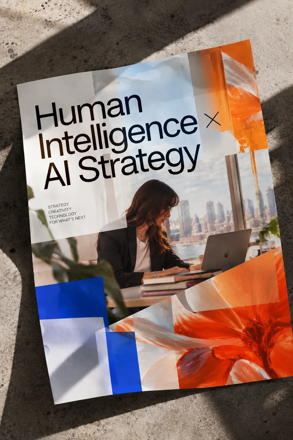 Póster editorial sobre el suelo: Human Intelligence × AI Strategy, con Florencia Sastre trabajando en su portátil